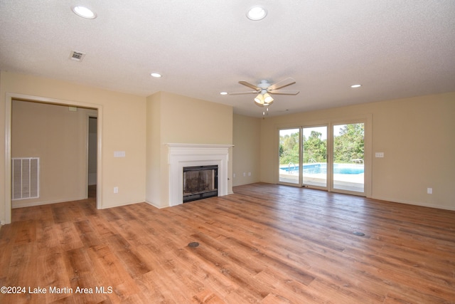 unfurnished living room featuring ceiling fan, a textured ceiling, and light wood-type flooring