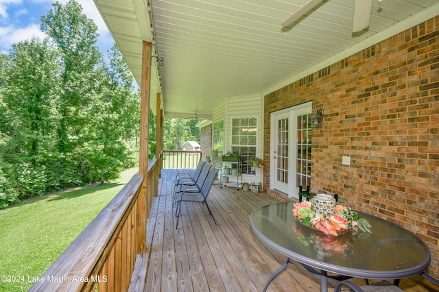 deck with a lawn and ceiling fan