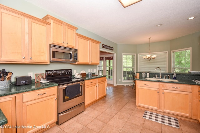 kitchen featuring appliances with stainless steel finishes, sink, light brown cabinets, pendant lighting, and a chandelier