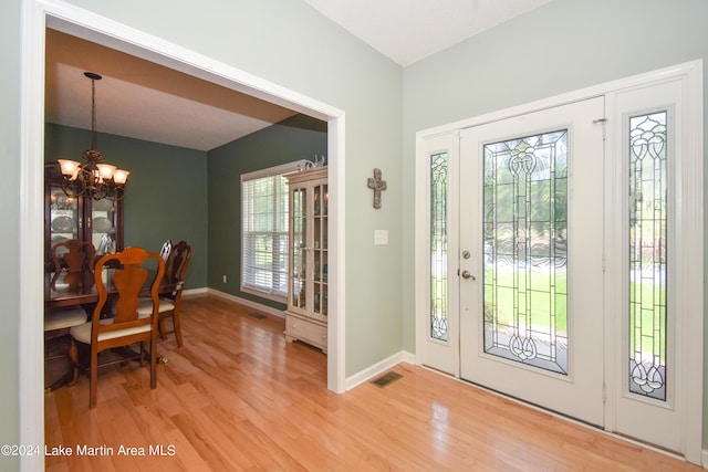 foyer entrance featuring light hardwood / wood-style floors and an inviting chandelier