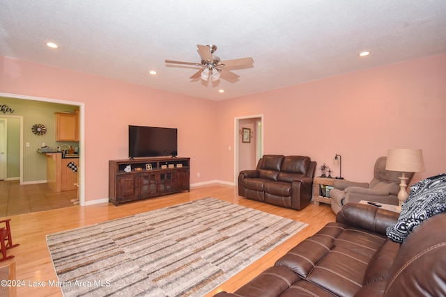 living room featuring ceiling fan and light hardwood / wood-style floors