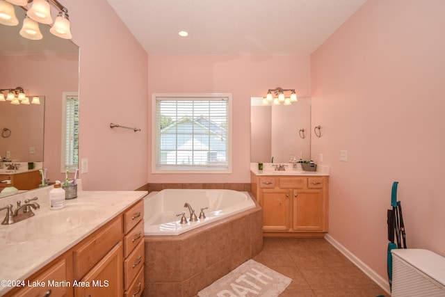 bathroom featuring tile patterned flooring, vanity, and tiled tub