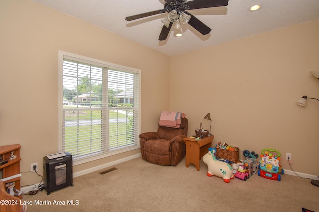 game room with light carpet, a textured ceiling, and ceiling fan