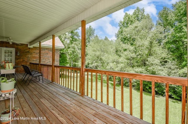 wooden deck with a lawn and ceiling fan