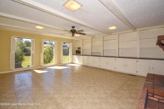 unfurnished room with beamed ceiling, a textured ceiling, and ceiling fan