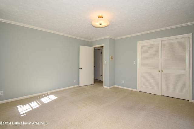 unfurnished bedroom featuring crown molding, light colored carpet, a textured ceiling, and a closet