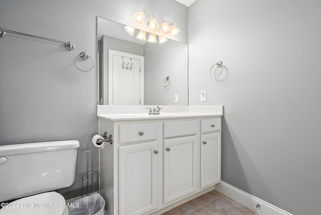 bathroom featuring tile patterned flooring, vanity, and toilet