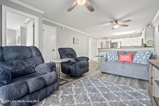 living room with ceiling fan, light wood-type flooring, and ornamental molding