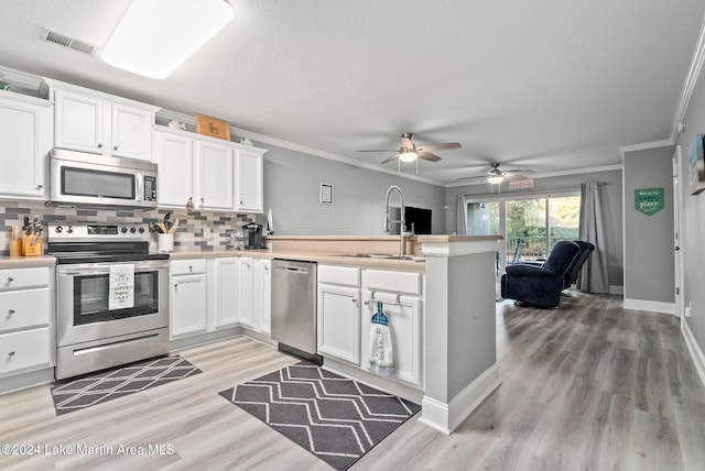 kitchen featuring white cabinets, appliances with stainless steel finishes, backsplash, and ceiling fan