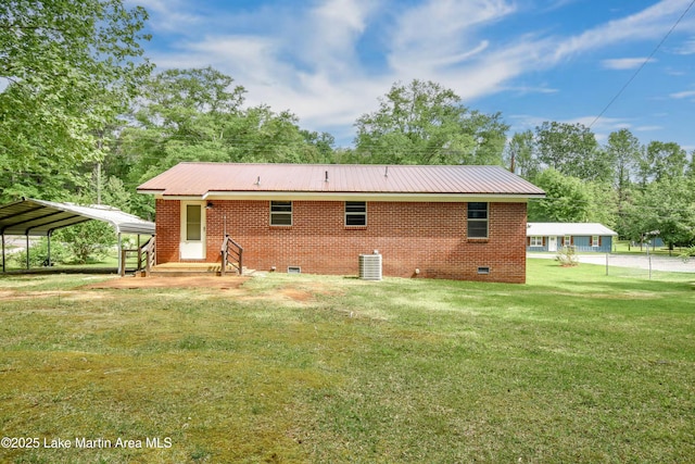 back of house with a detached carport, cooling unit, metal roof, a lawn, and crawl space