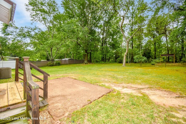 view of yard with central AC, fence, and a patio area