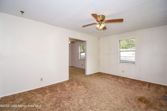 carpeted spare room with a ceiling fan