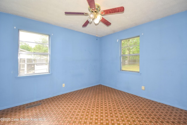 unfurnished room with visible vents, baseboards, and ceiling fan