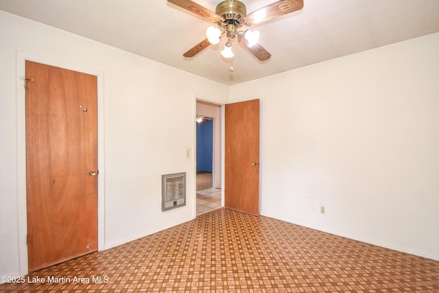 empty room with tile patterned floors and a ceiling fan