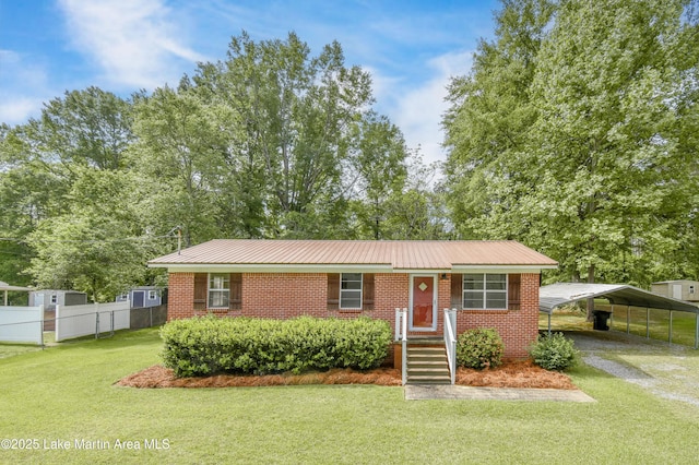 ranch-style home featuring driveway, a carport, fence, a front yard, and metal roof