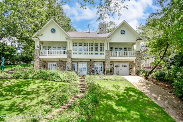 view of front of house with a garage, a balcony, and a front yard