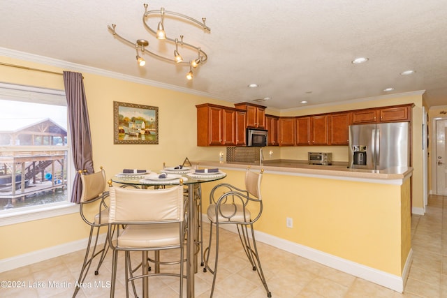 kitchen featuring a kitchen bar, crown molding, kitchen peninsula, and stainless steel appliances