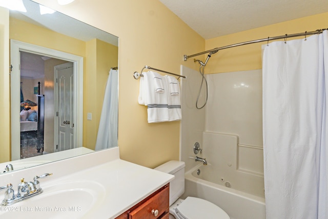 full bathroom with a textured ceiling, vanity, toilet, and shower / bath combo with shower curtain