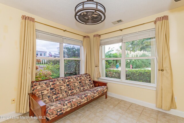 living area with tile patterned floors and a textured ceiling