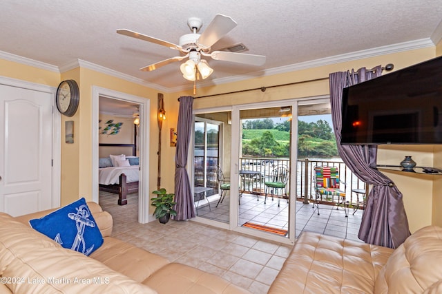 tiled living room featuring ceiling fan, a textured ceiling, and ornamental molding