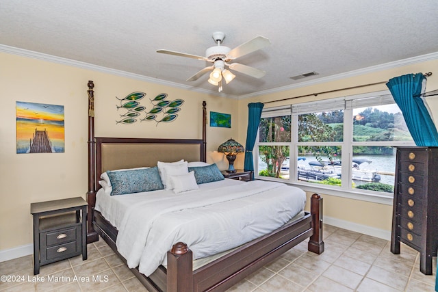 tiled bedroom with a textured ceiling, ceiling fan, and crown molding