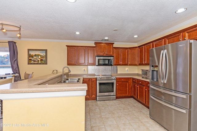 kitchen with crown molding, sink, tasteful backsplash, kitchen peninsula, and stainless steel appliances