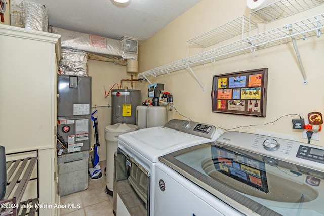 laundry area with light tile patterned flooring, independent washer and dryer, heating unit, and water heater