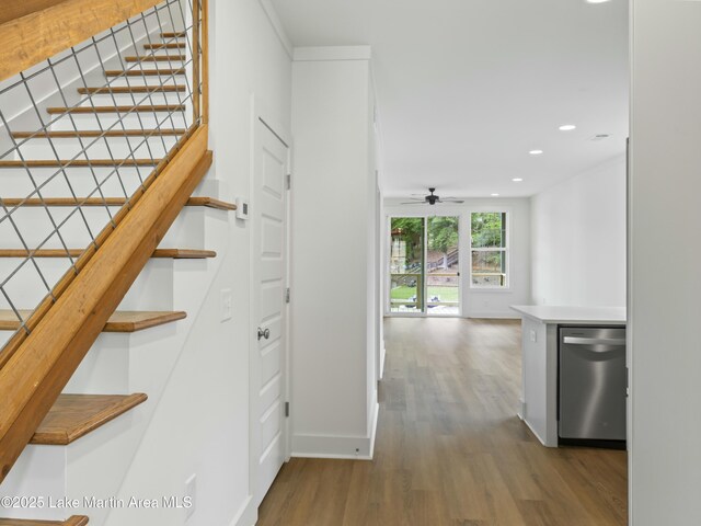 stairs featuring baseboards, wood finished floors, and recessed lighting