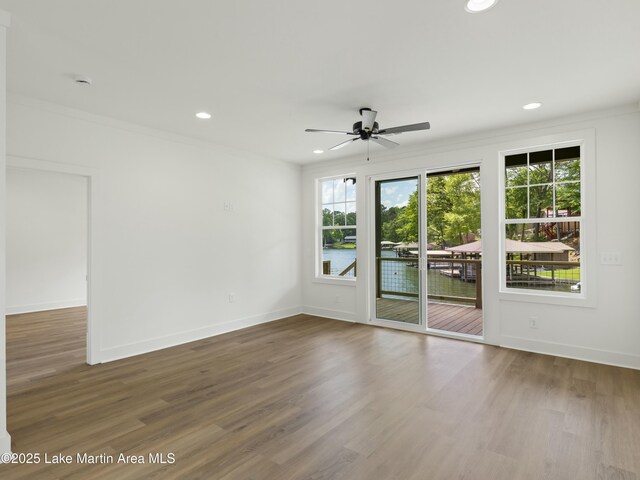 empty room featuring recessed lighting, wood finished floors, a ceiling fan, baseboards, and crown molding