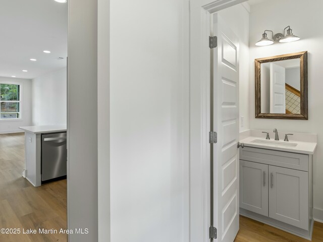 bathroom featuring wood finished floors, vanity, and recessed lighting