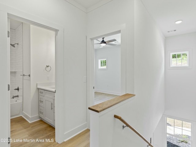 bathroom with a wealth of natural light, tub / shower combination, wood finished floors, and vanity