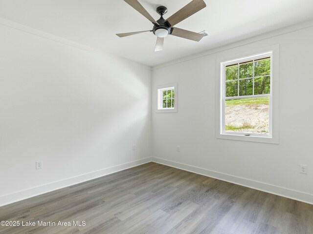 empty room with a ceiling fan, visible vents, baseboards, and wood finished floors