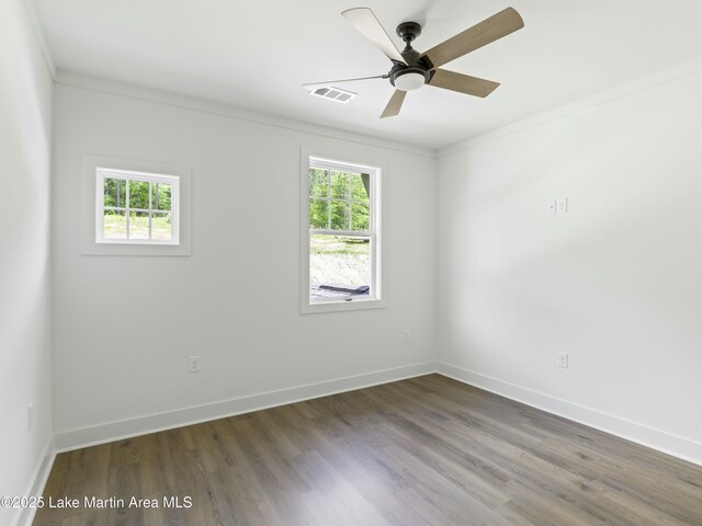 spare room with baseboards, a wealth of natural light, and wood finished floors