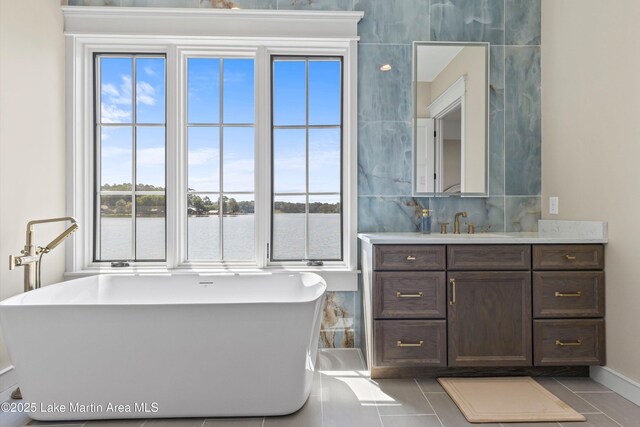 116 Water Oak Ln, Jacksons Gap, AL 36861 - full bath with vanity, a freestanding bath, tile patterned floors, decorative backsplash, and a water view