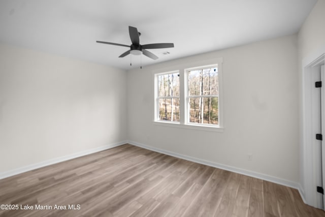 unfurnished bedroom with a ceiling fan, visible vents, wood finished floors, and baseboards