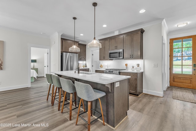189 Magnolia Way, Dadeville, AL 36853 - kitchen with appliances with stainless steel finishes, a sink, baseboards, ornamental molding, and a breakfast bar area