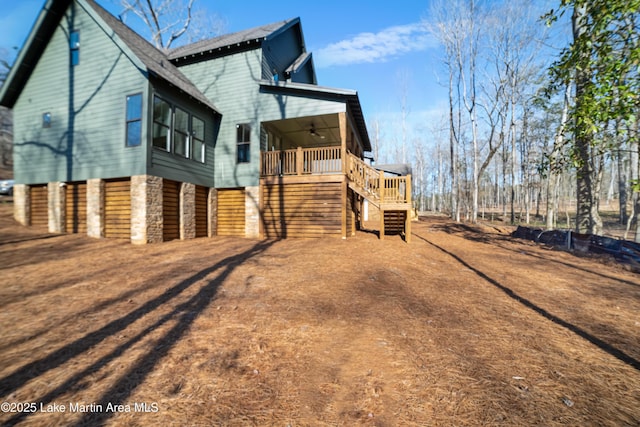 view of property exterior featuring stone siding, stairs, and ceiling fan