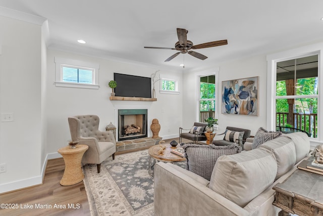 189 Magnolia Way, Dadeville, AL 36853 - living room featuring wood finished floors, a fireplace with raised hearth, a ceiling fan, baseboards, and ornamental molding