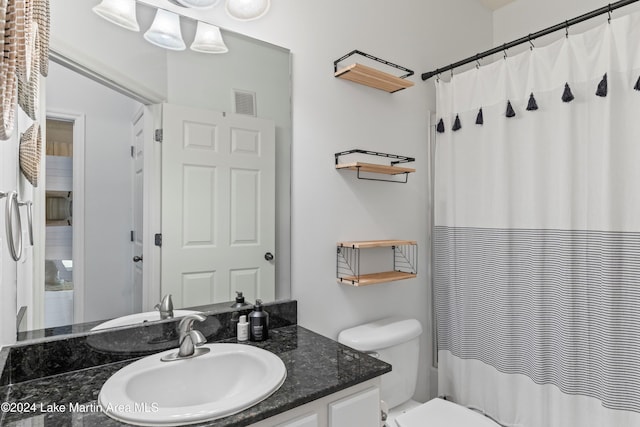 bathroom with toilet, a shower with curtain, and vanity