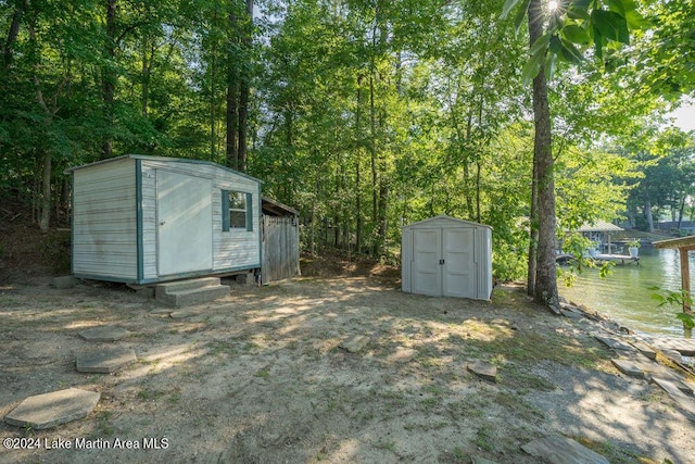 view of yard featuring a water view and a storage unit