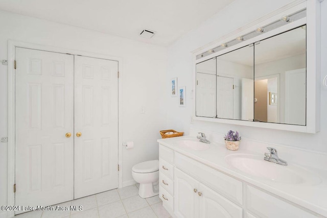 bathroom with tile patterned flooring, vanity, and toilet