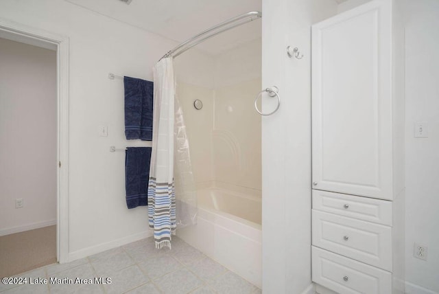 bathroom with tile patterned floors and shower / bath combo with shower curtain