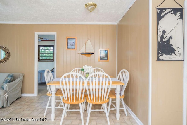 dining space featuring wood walls and ornamental molding