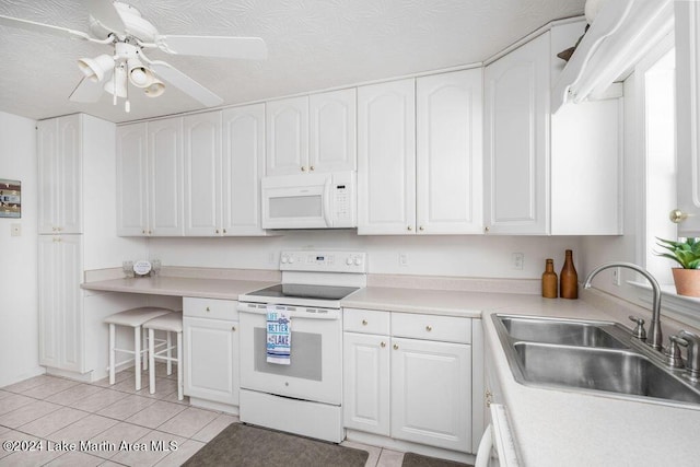 kitchen with a textured ceiling, white cabinetry, white appliances, and sink