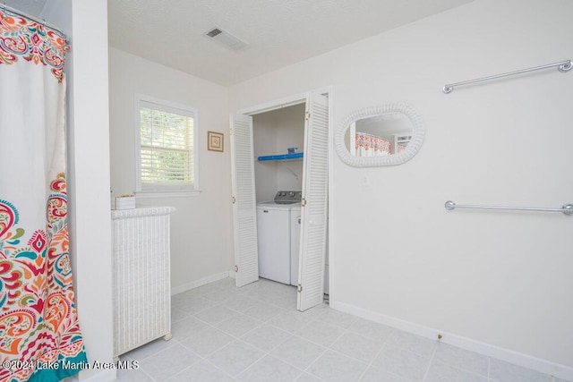 bathroom featuring washer and dryer and a textured ceiling