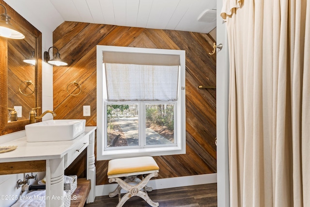 office area featuring lofted ceiling, wood walls, visible vents, and a sink