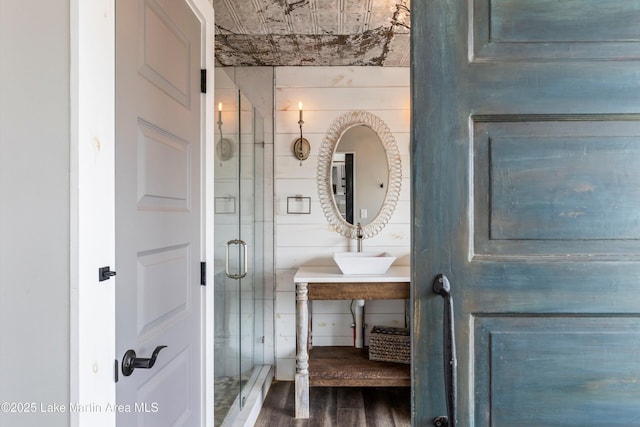 full bathroom with a shower stall, wood finished floors, and vanity