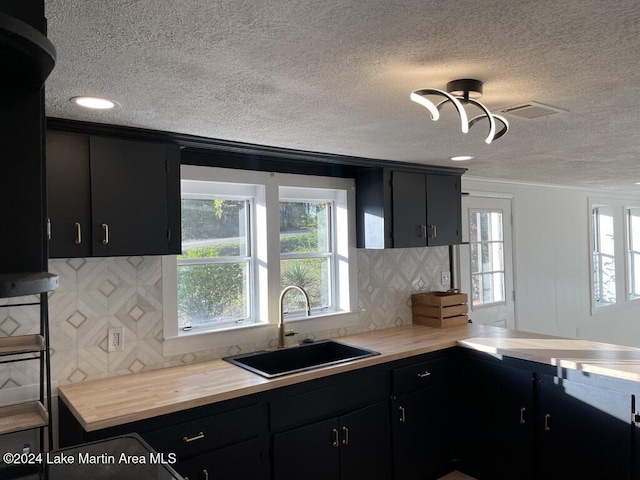 kitchen with backsplash, sink, and a textured ceiling