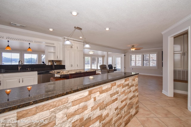 kitchen featuring a sink, visible vents, a center island, dishwasher, and crown molding