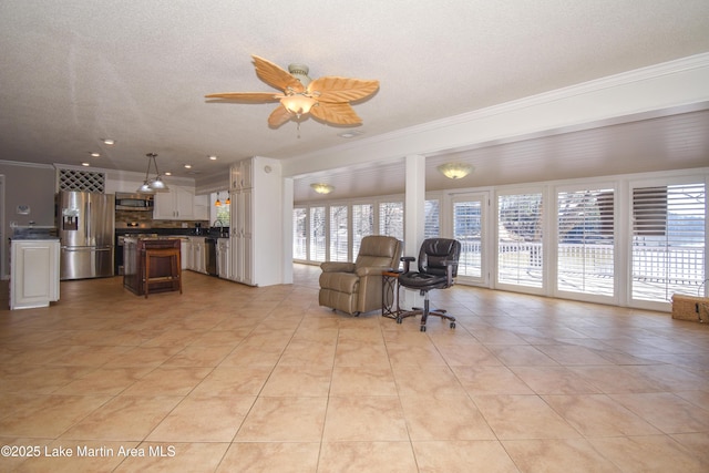 living area with ornamental molding, light tile patterned floors, a textured ceiling, and a ceiling fan